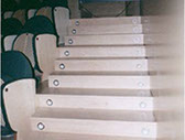 En la imagen se observa una escalera accesible. Falta pasamanos lateral y señalizar con cambio de color o textura la huella y contrahuella. Esca