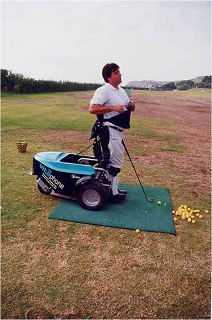 Jugador de golf en silla de ruedas:Jugador de golf en una silla de ruedas que se eleva para poder realizar los movimientos en posición "de pie" 