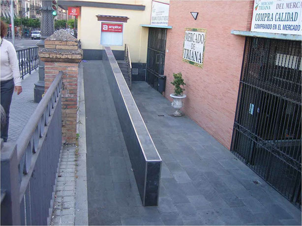 Rampas al exterior. No accesible. Falta pasamanos laterales. Pendiente excesiva. Imbornal en mismo sentido de la marcha. 